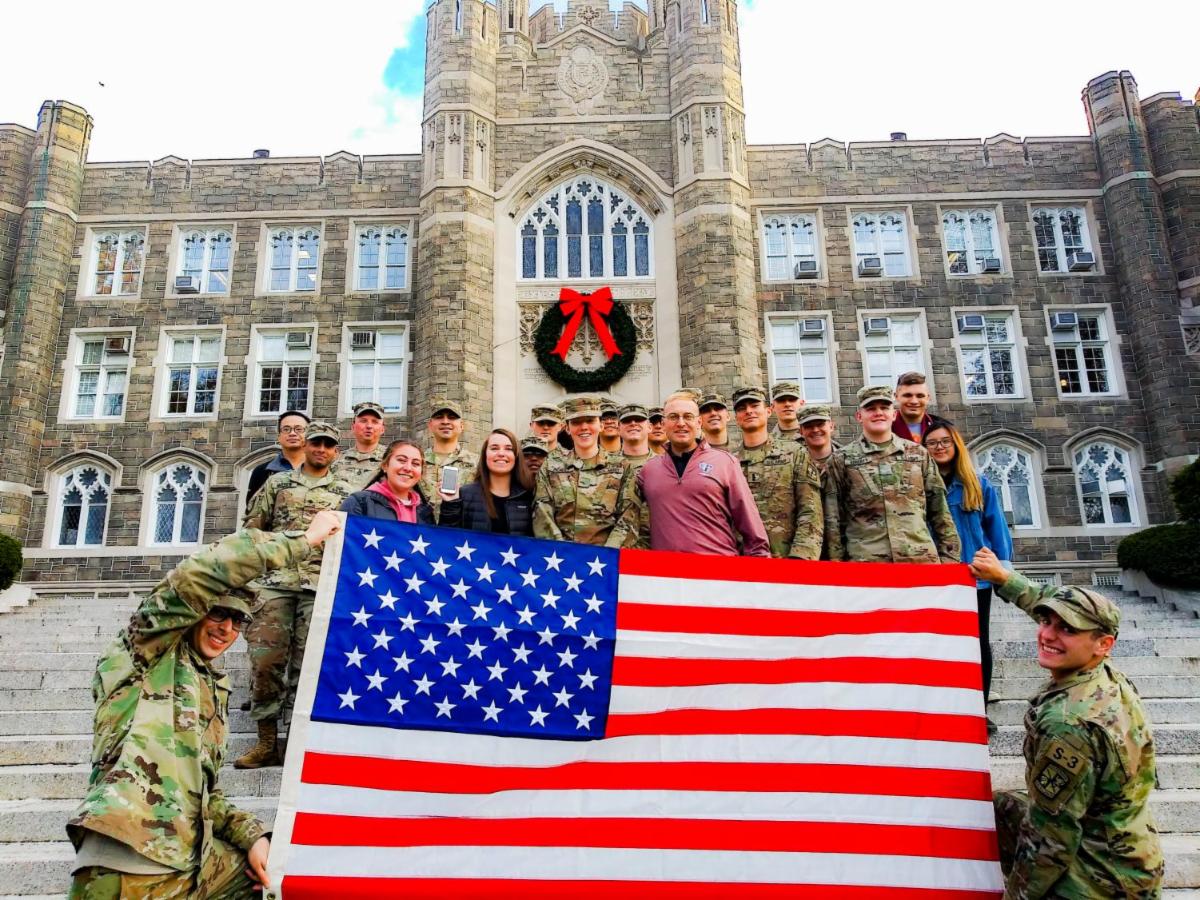 ROTC cadets with flag in front of Keating Hall