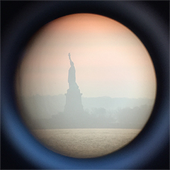 Image is of the Statute of Liberty through a sightseeing telescope near New York City’s Pier 40.