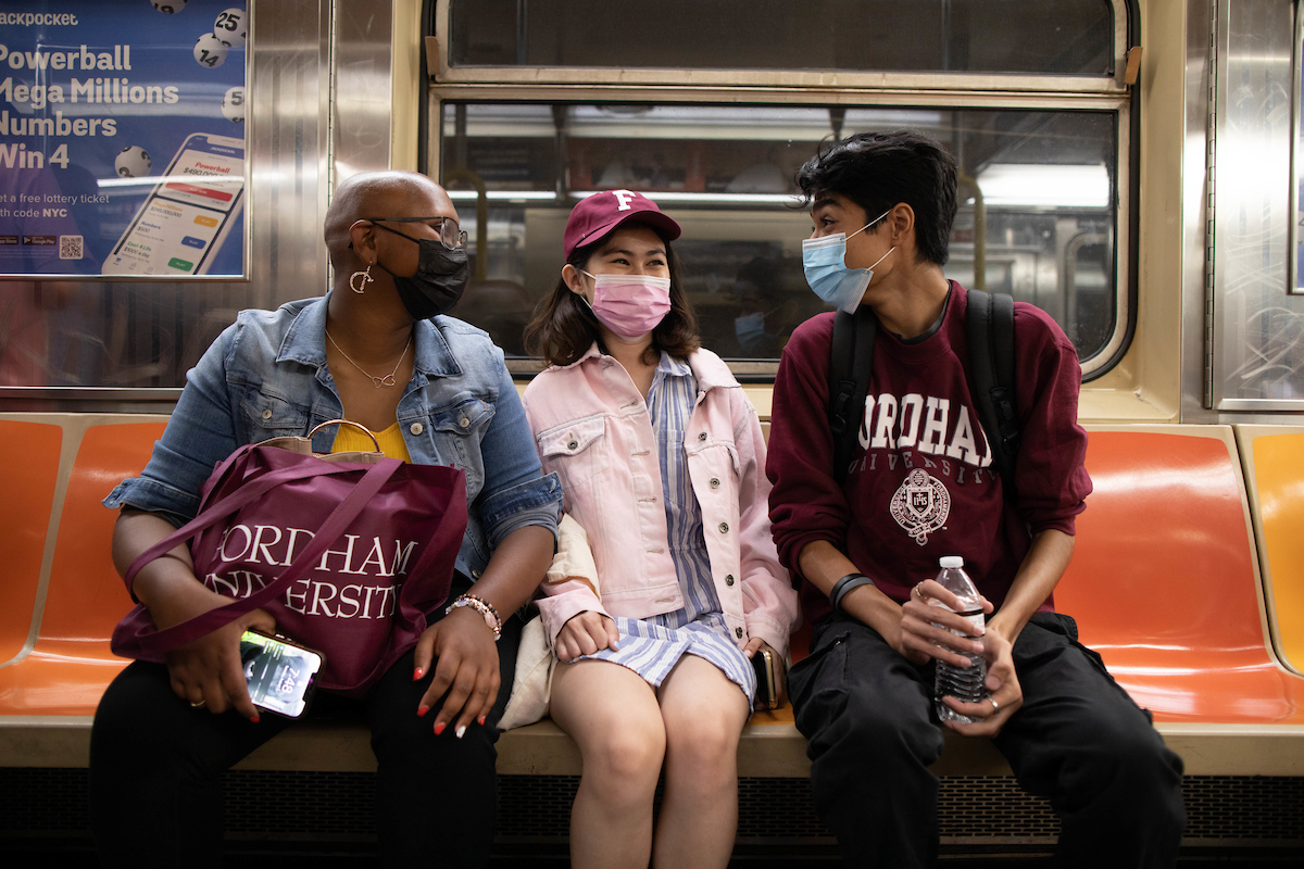 Three masked students on the New York City Subway