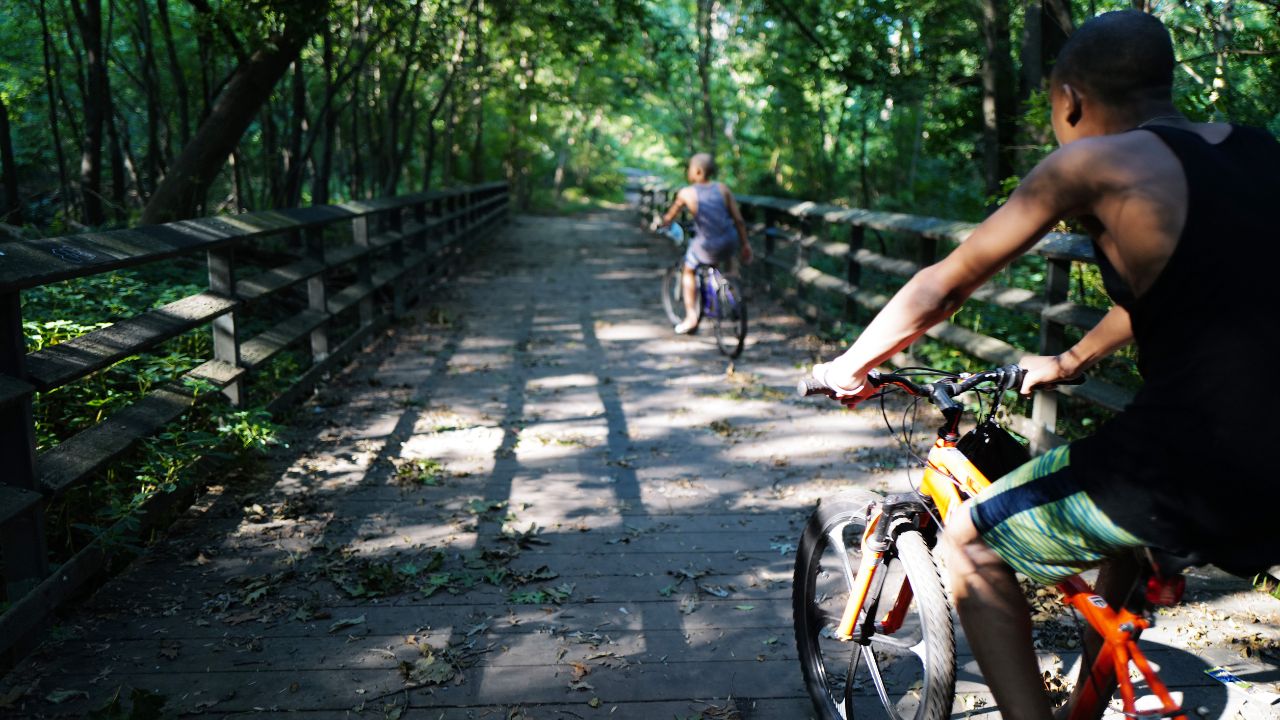 Two kids ride bikes along the Bronx River Greenway