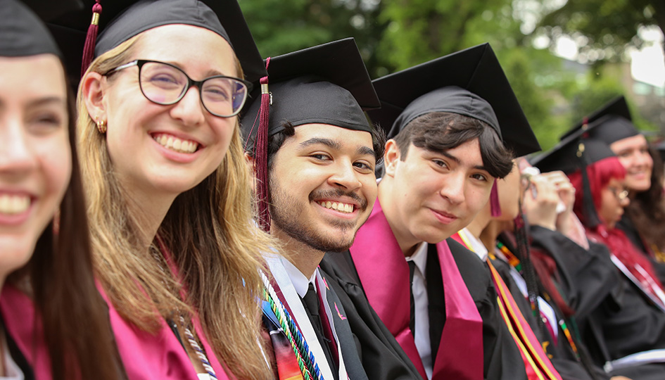 Students seated and smiling at Graduation
