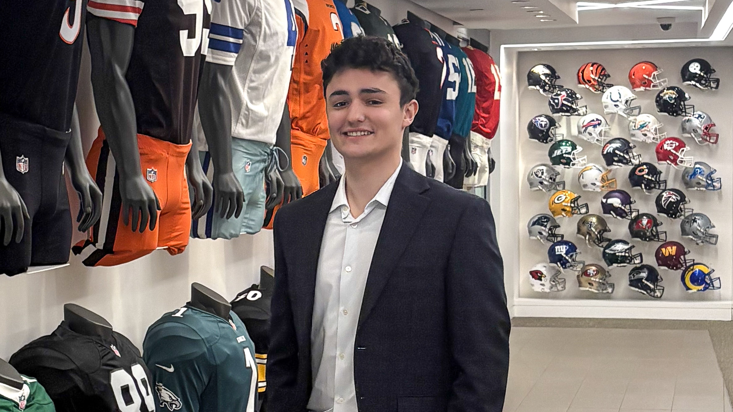 Chris Orlando poses in front of a wall of memorabilia in the NFL Offices