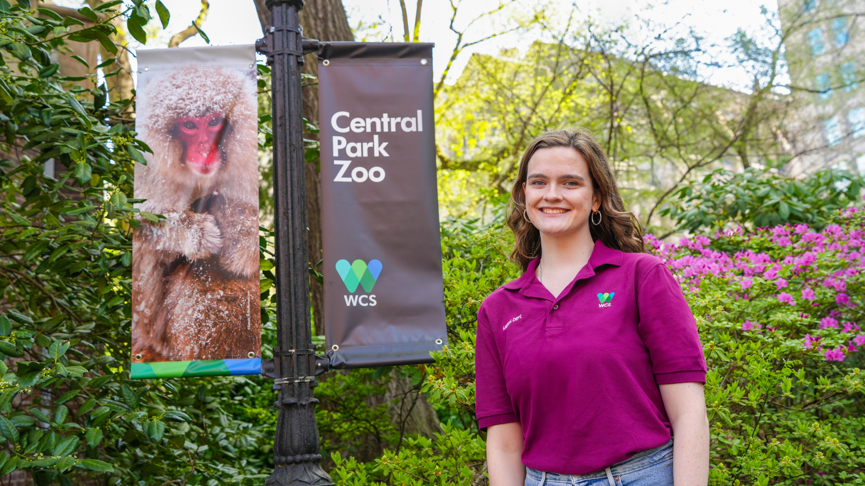 A student smiles next to a Central Park Zoo sign.