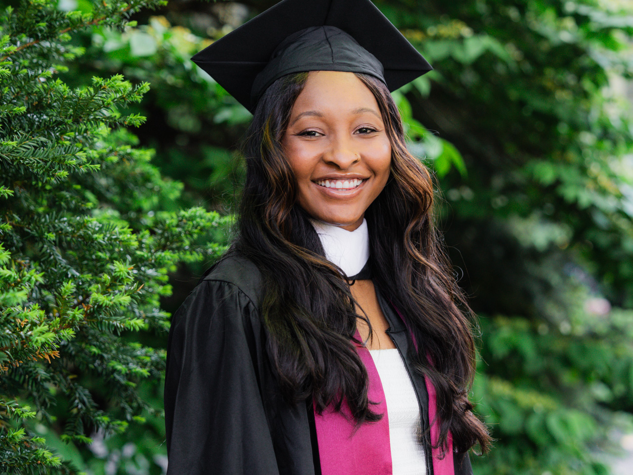 Taylor Donaldson standing in front of a shrub at Fordham's Commencement at Rose Hill