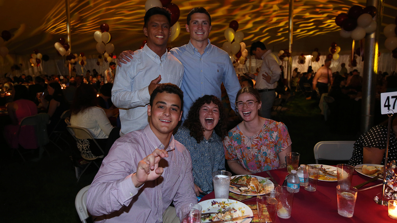 Students and their families smile at a table