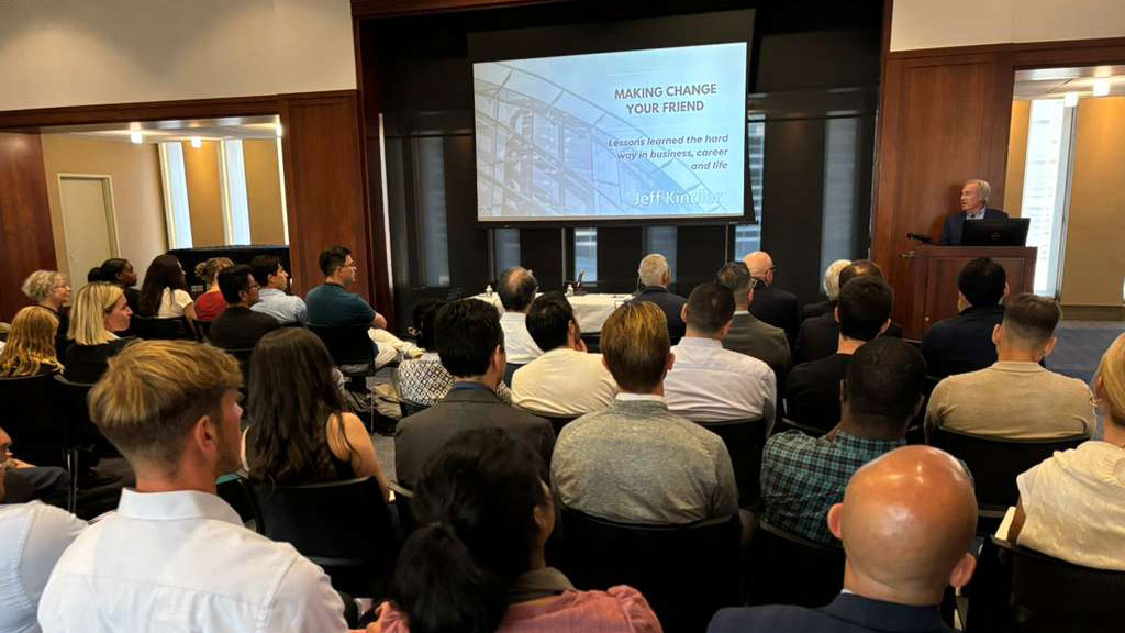 An executive speaks to a group of people in a room