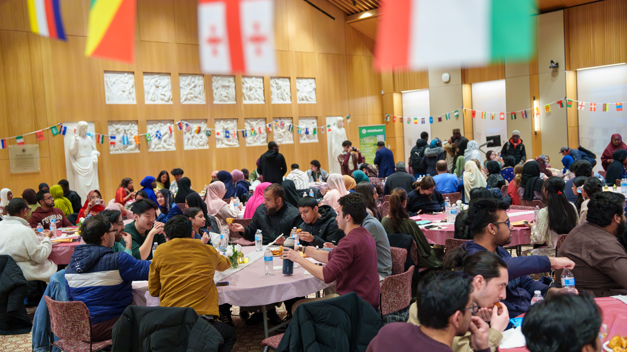 People sitting at tables eat.