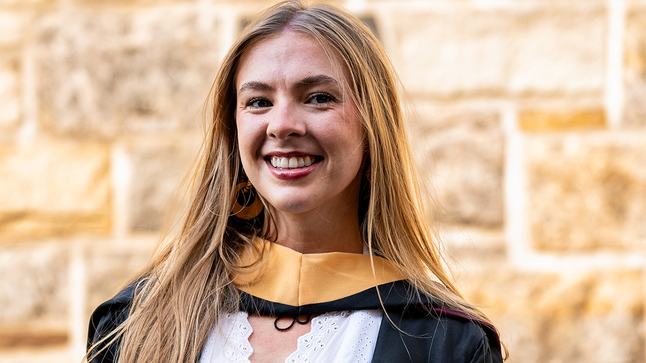 GSS grad Meagan Cunney posing at Commencement at Rose Hill