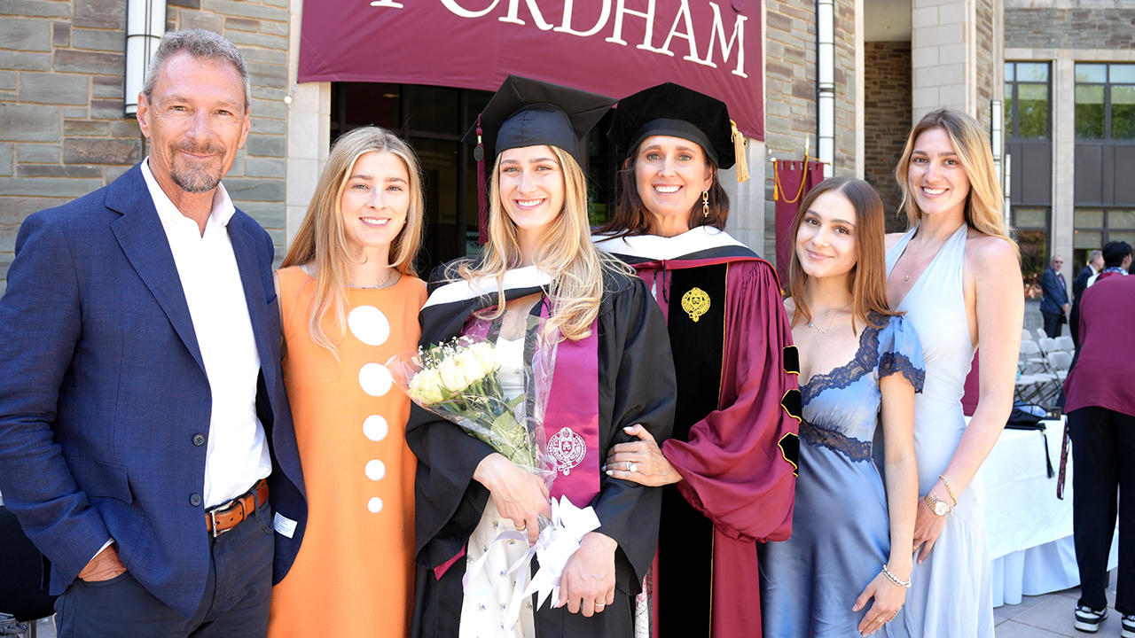 A family poses in front of Walsh Library
