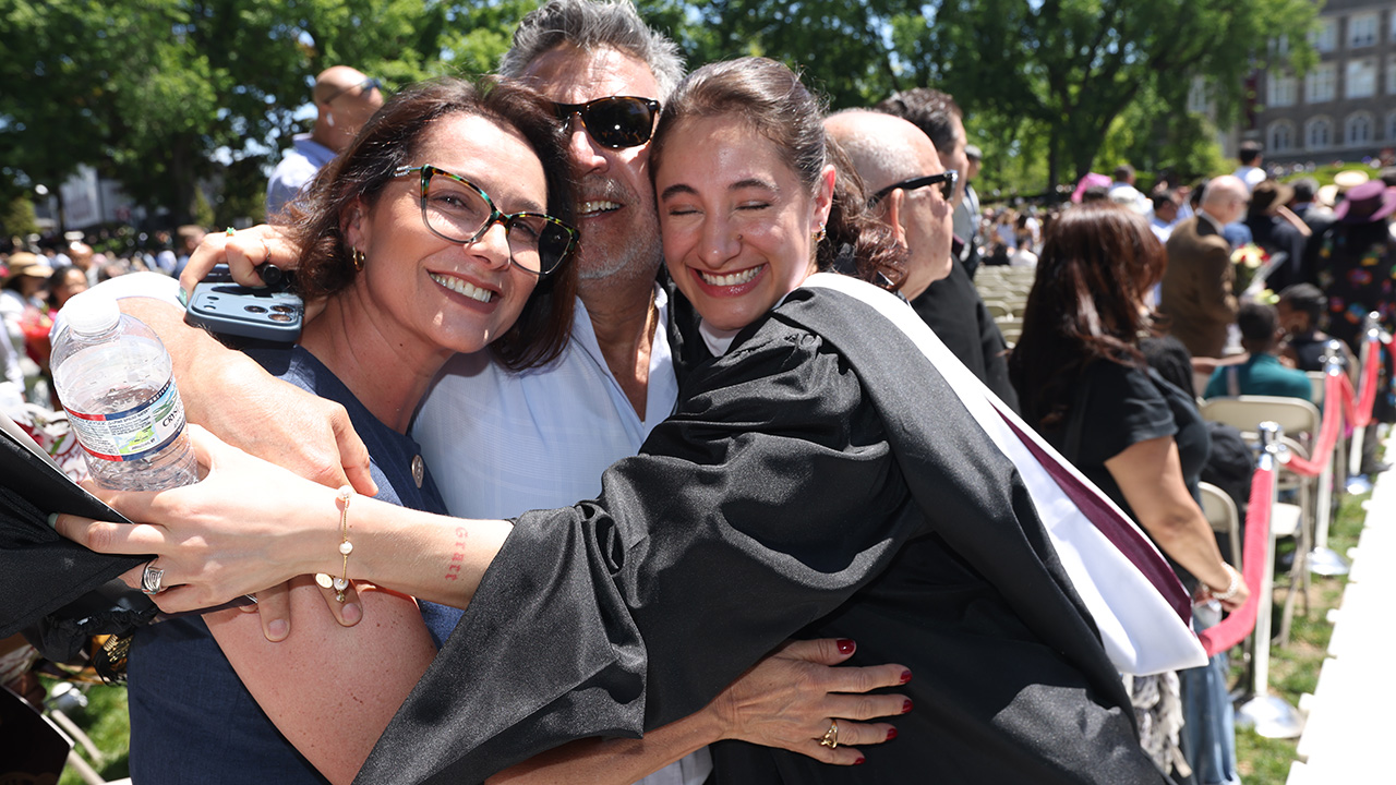 A student hugs her parents