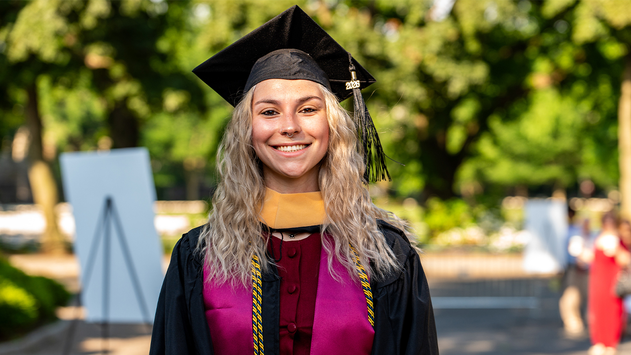 GSS grad Emma Morino posing at Commencement at Rose Hill