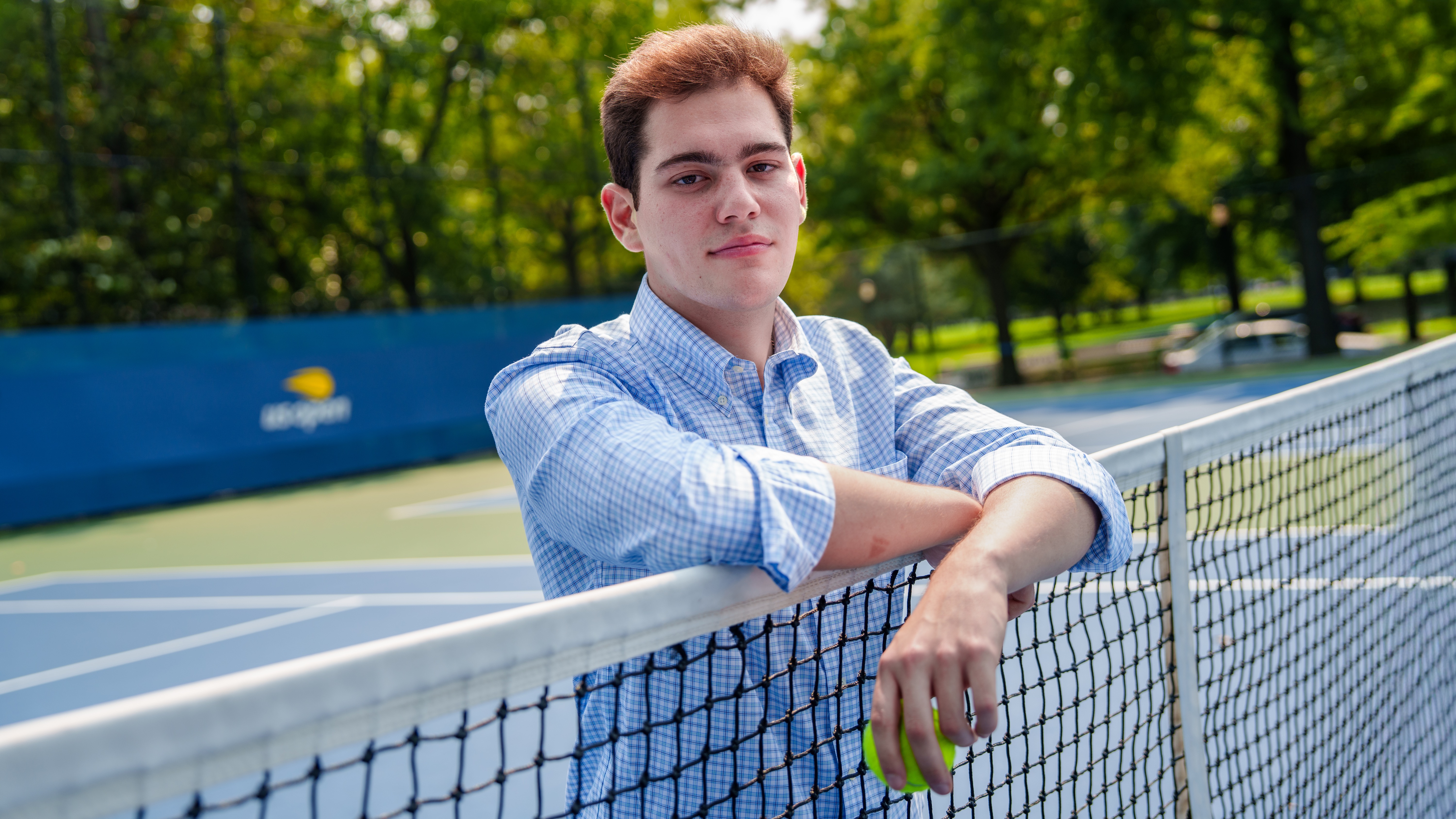 A student posing in a tennis court