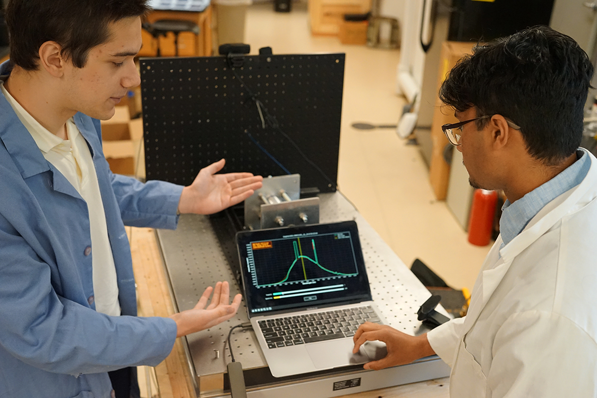 Two students examine the rocket engine results.