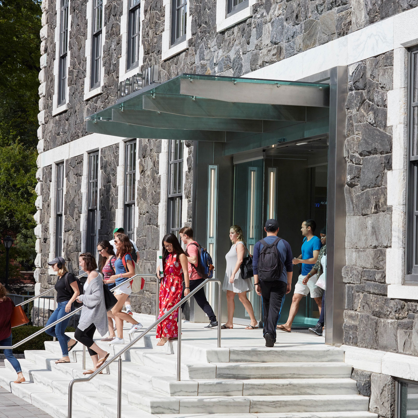 Students enter and leave Hughes Hall, home of the Gabelli School of Business on the Rose Hill camus
