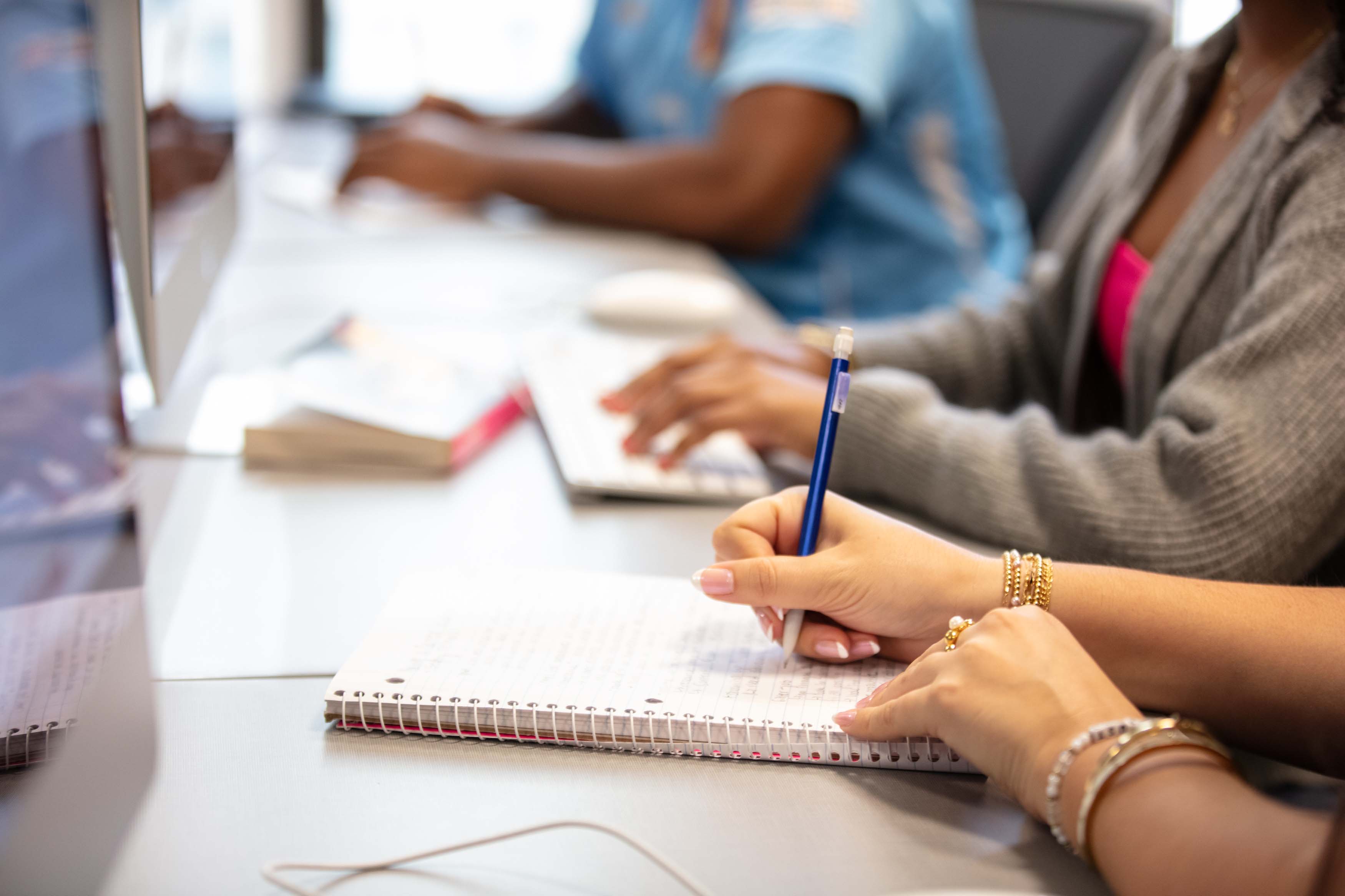 student writing in a notebook and keyboard closeup