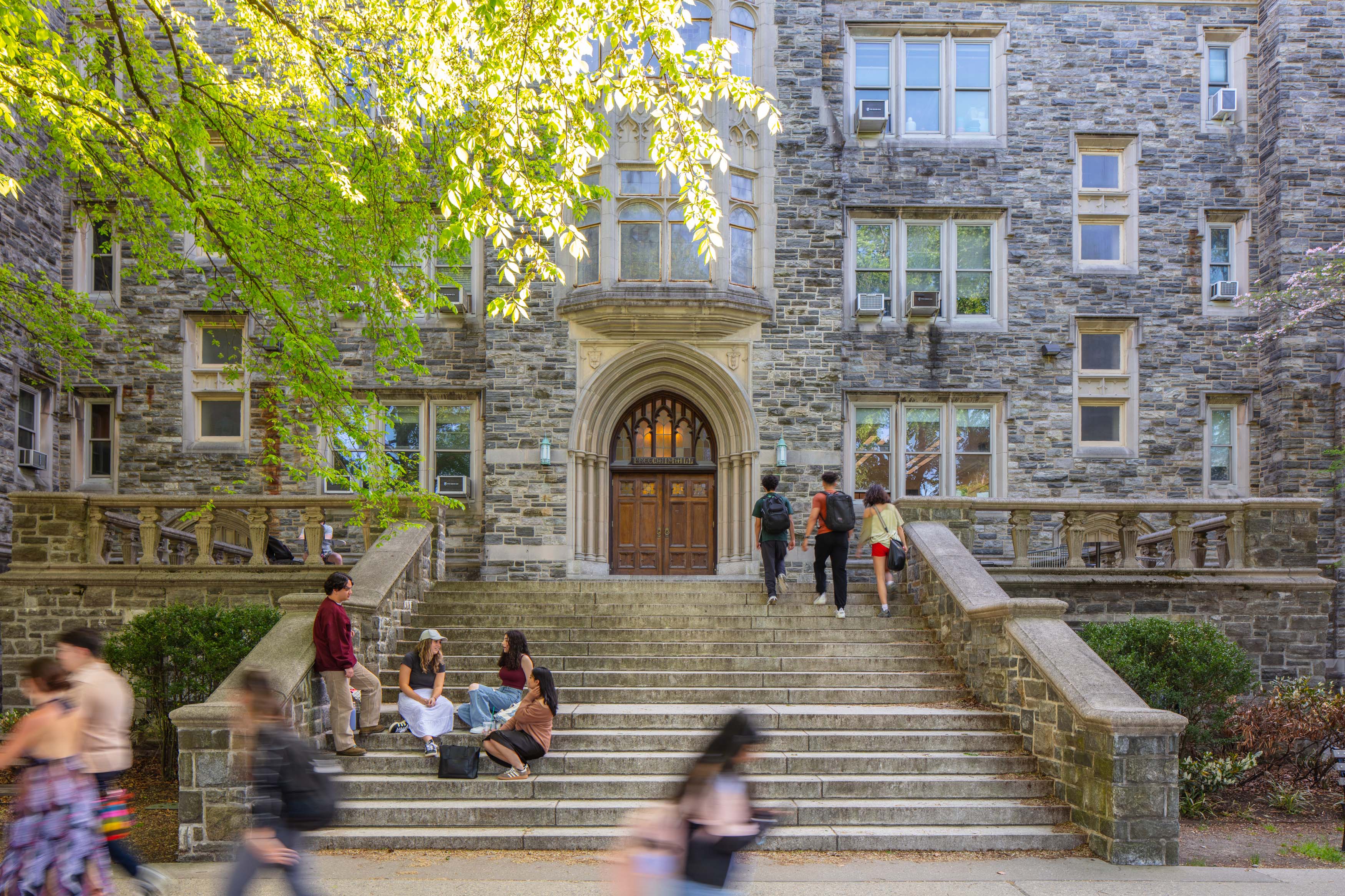 students sitting on steps and walking on Rose Hill Campus