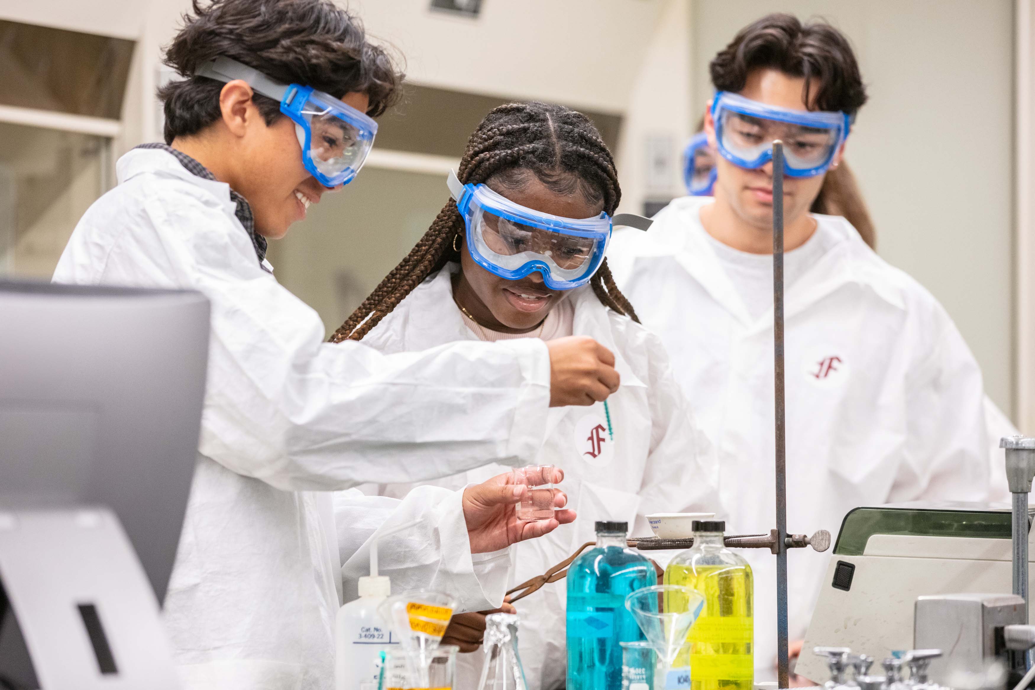 three students in science lap with goggles