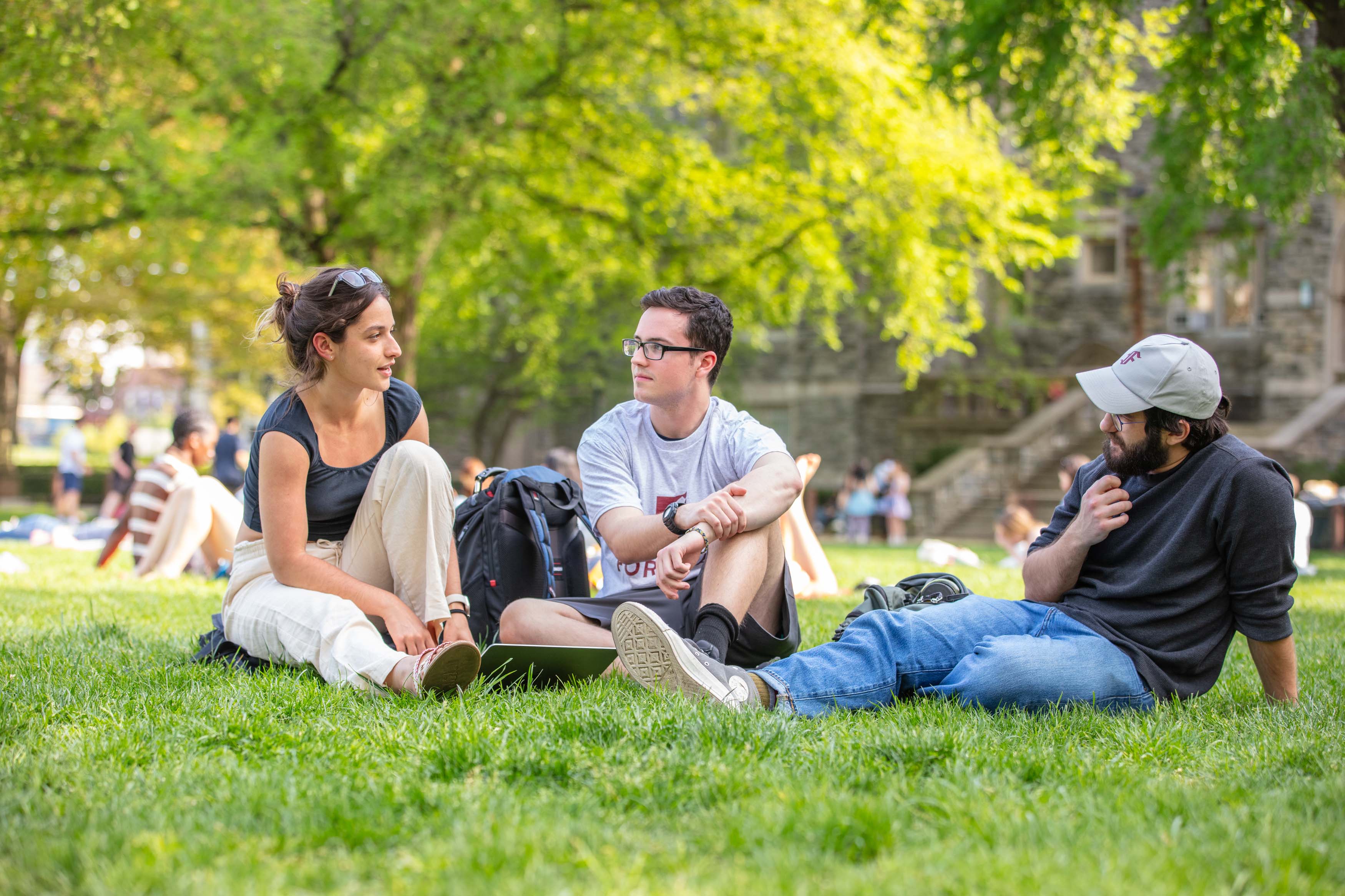 three students sitting on Edwards Parade talking
