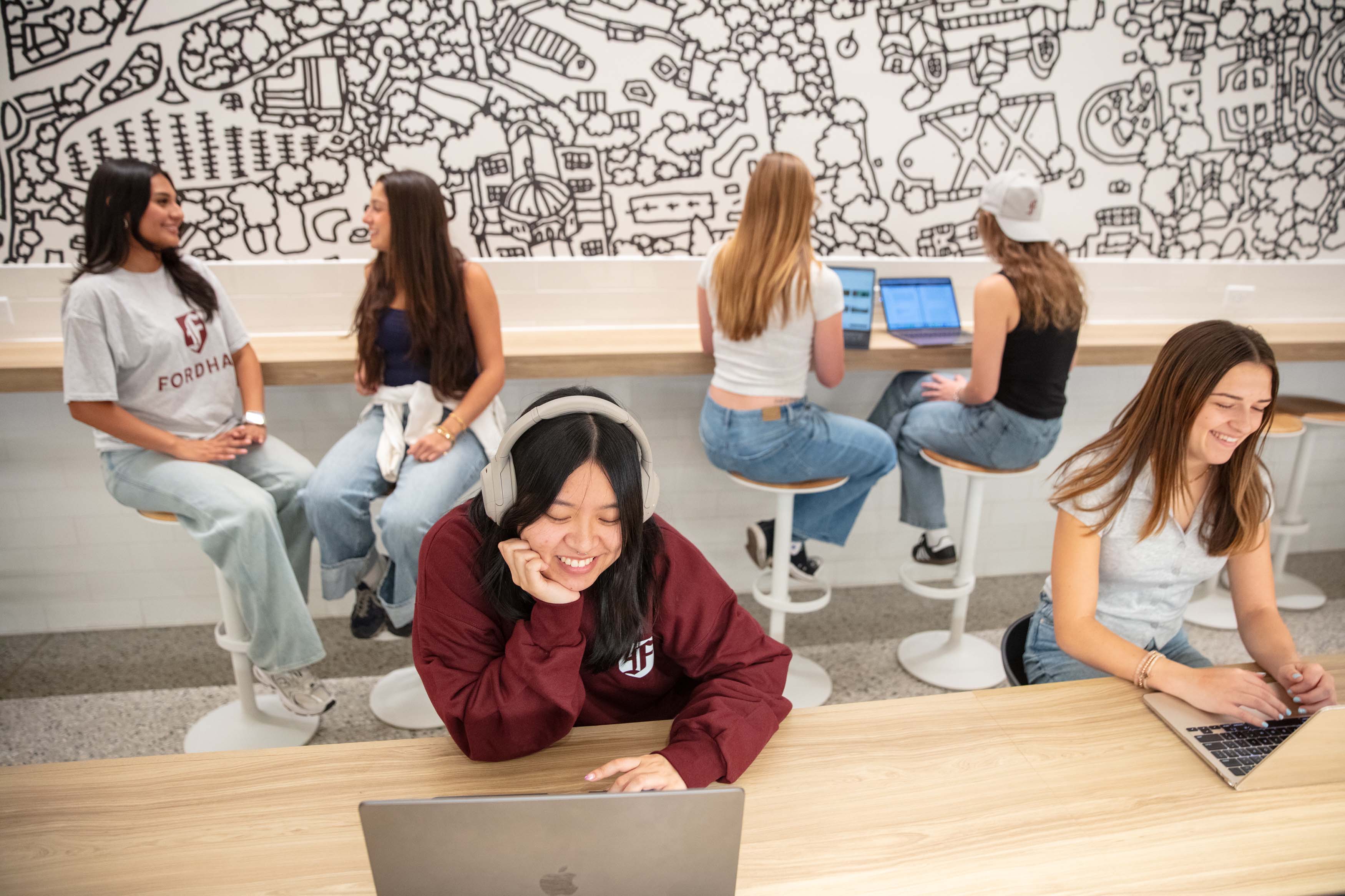 two students sitting at table on laptops