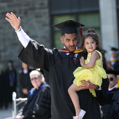 Graduated Student Holding Child and Waving.