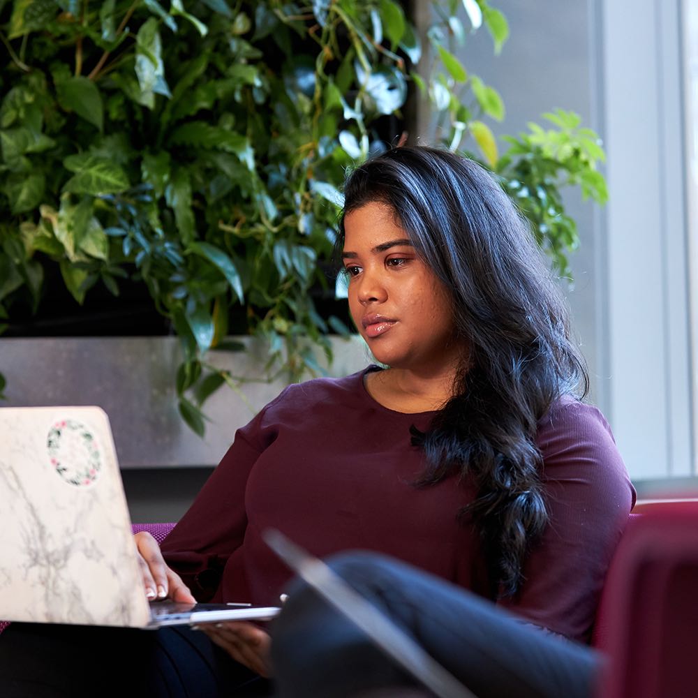 Student in seating area on laptop