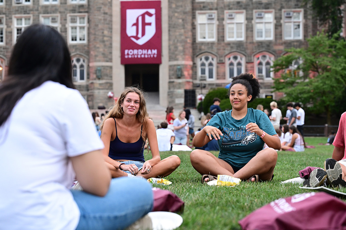 Two female students sitting on grass on Edward's Parade