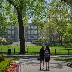 Two Students Talking In Front of the Keating Hall Lawn.