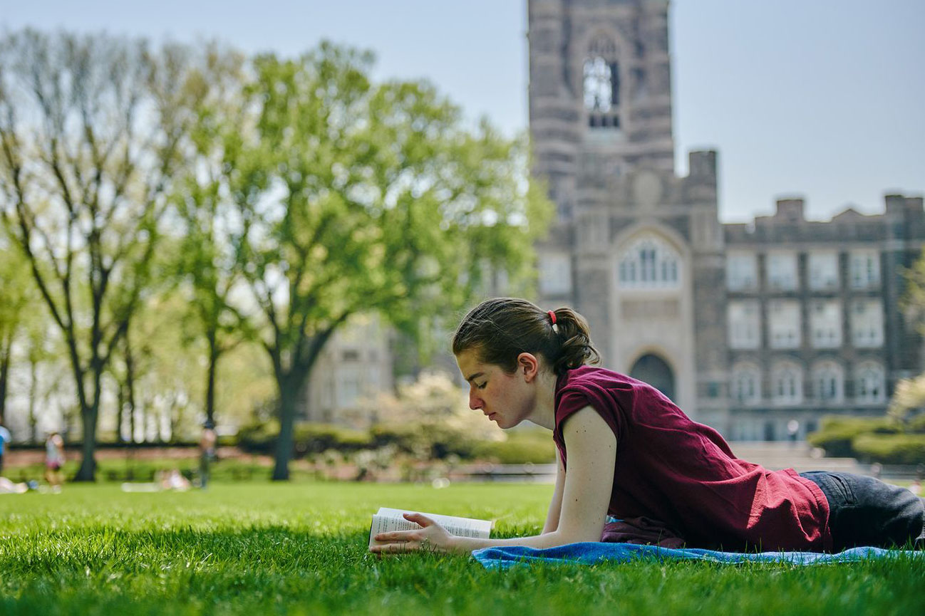 Rose Hill Student Reading in Plaza in Front of Keating Hall.