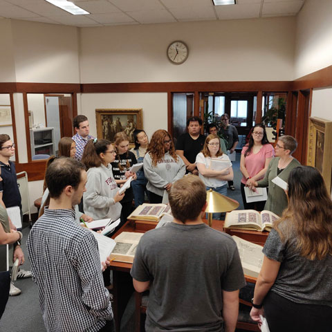 A class meets in Special Collections in the Walsh Library to examine Judaica.