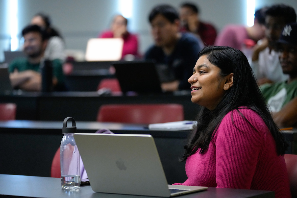 Graduate students in MBA classroom with laptops