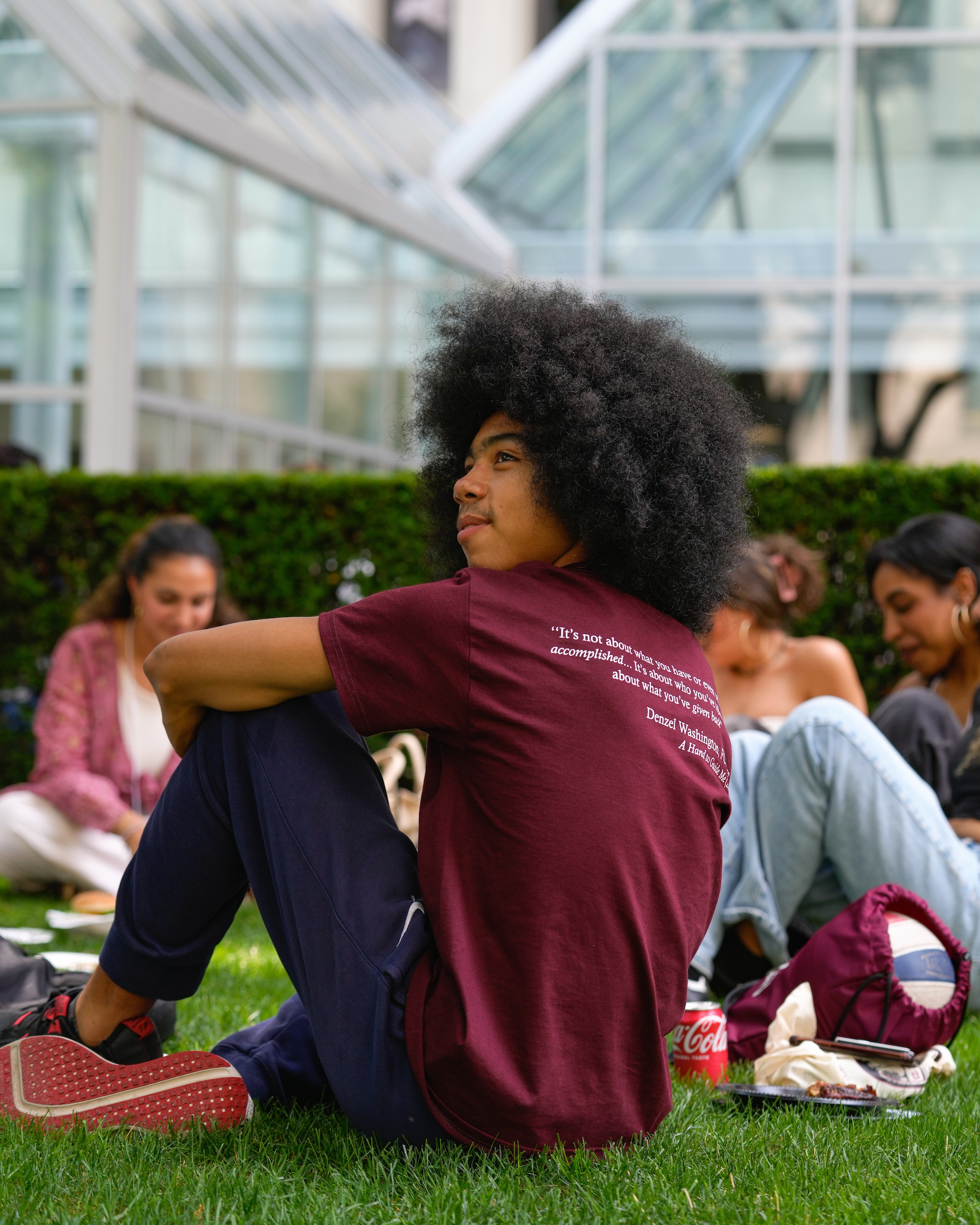 Fordham student sitting in the grass in LC Plaza