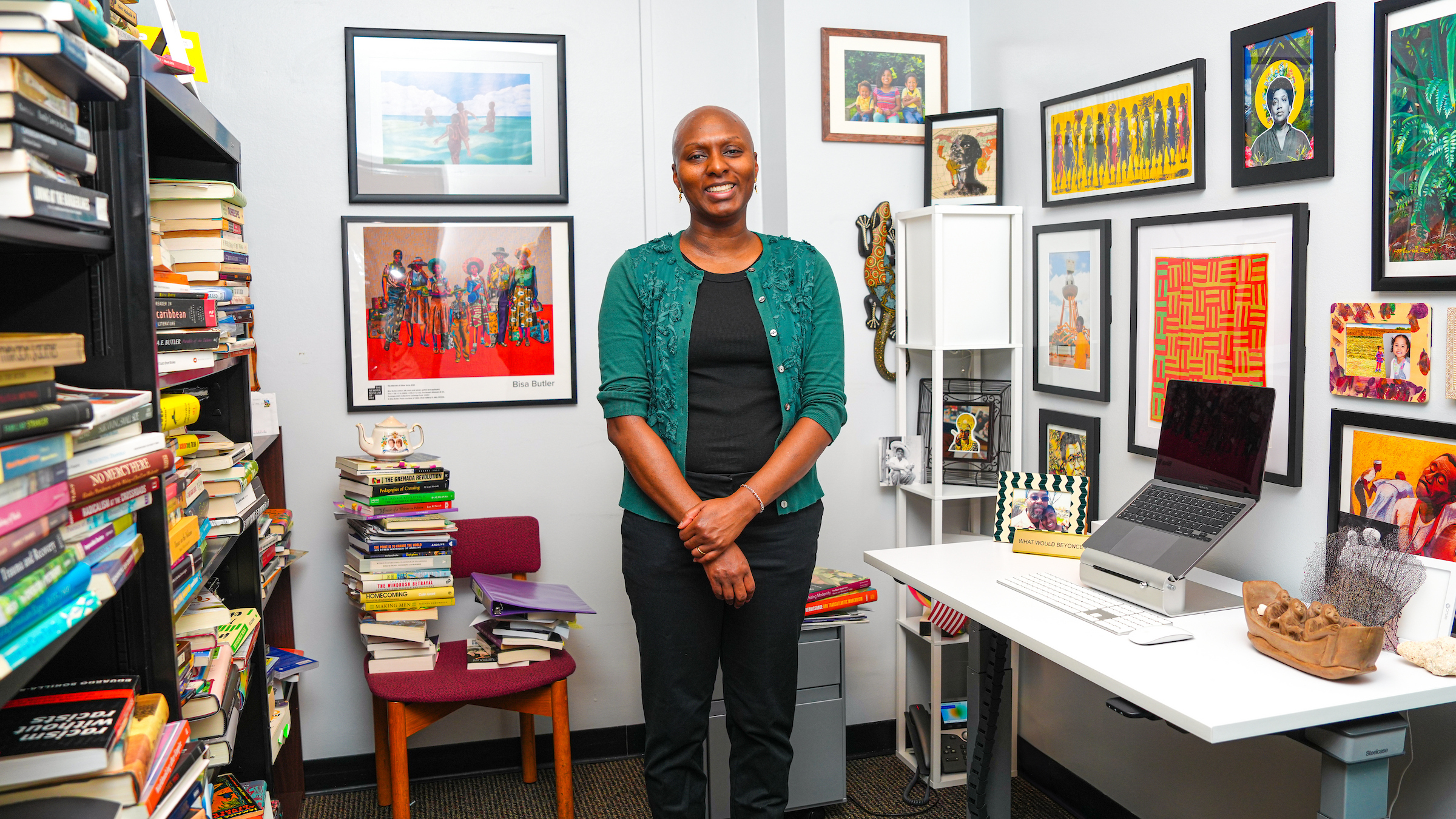 Laurie Lambert poses in her office, surrounded by framed works of art