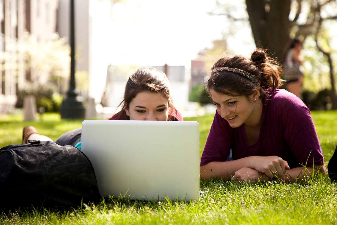 Two students sharing a computer to look at the screen together.