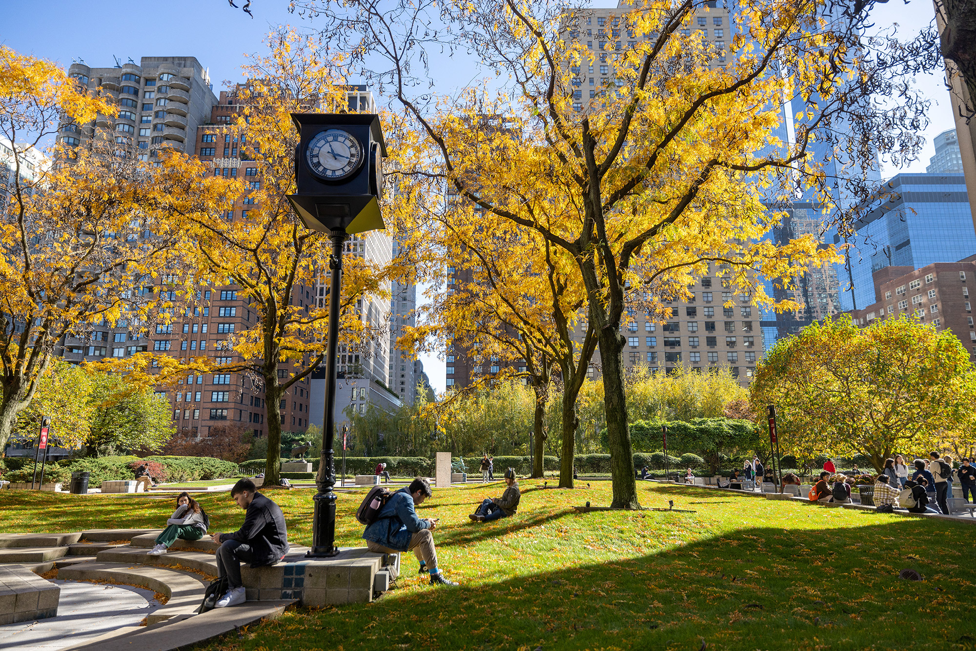 Students sitting on the plaza at Lincoln Center during the Fall
