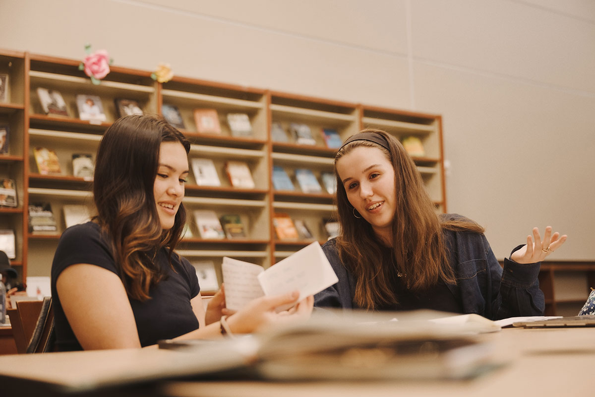 Two female Fordham students studying together in the library