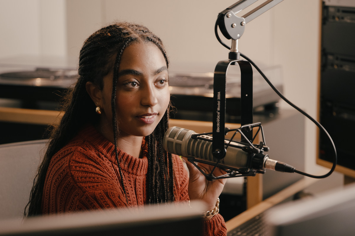 Female student in a studio with a microphone