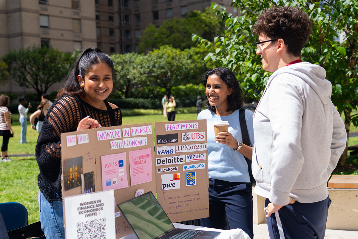 Economics students showing a poster at a student club fair