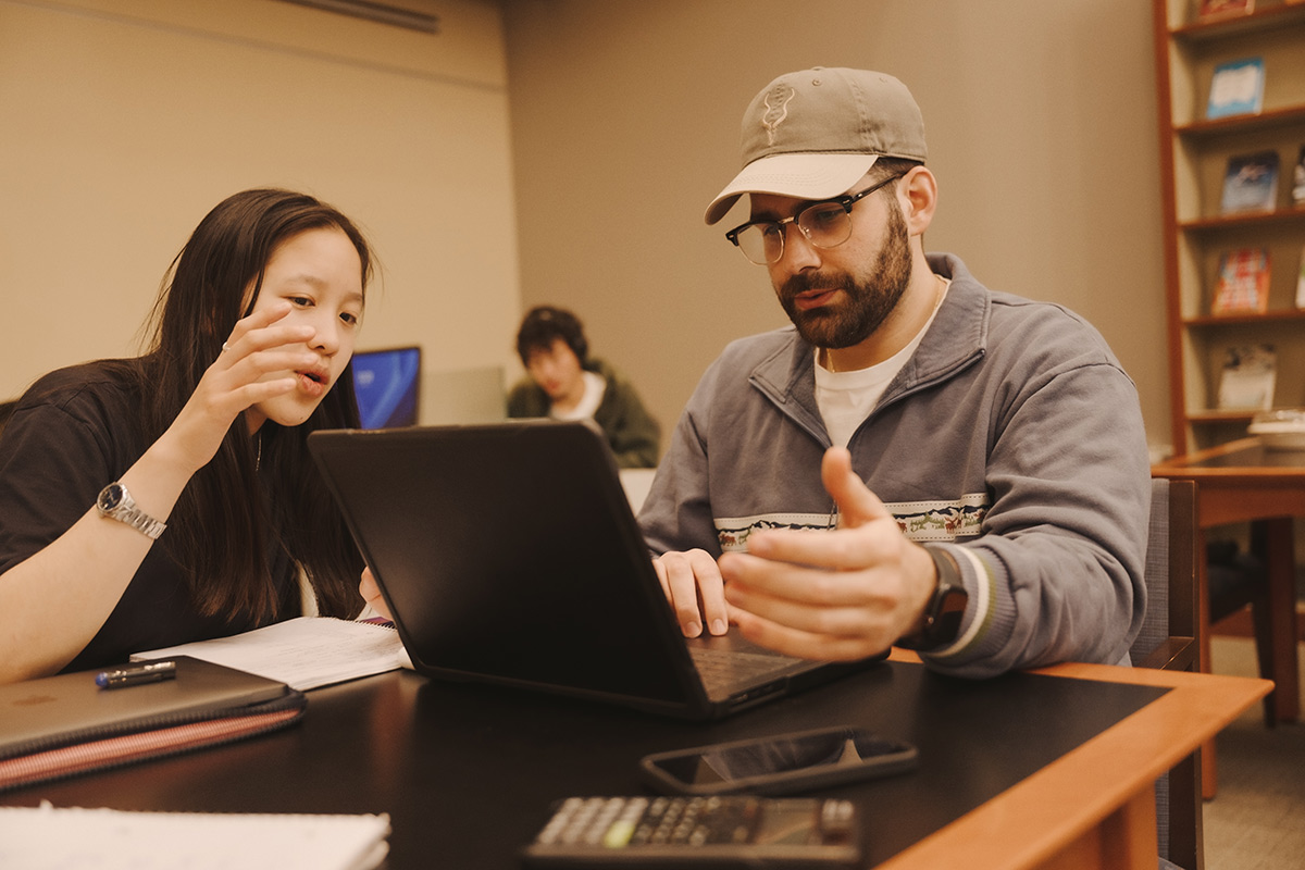 Two Fordham students working together in a classroom