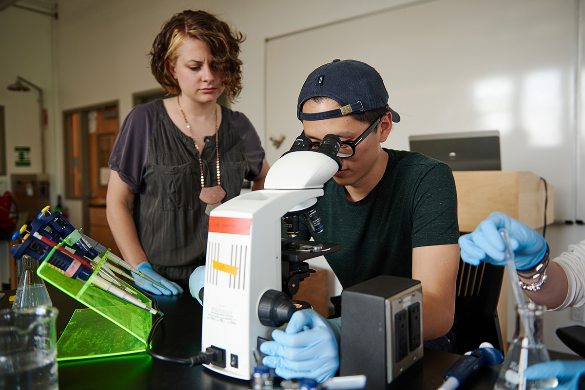 Two students using a microscope in a lab