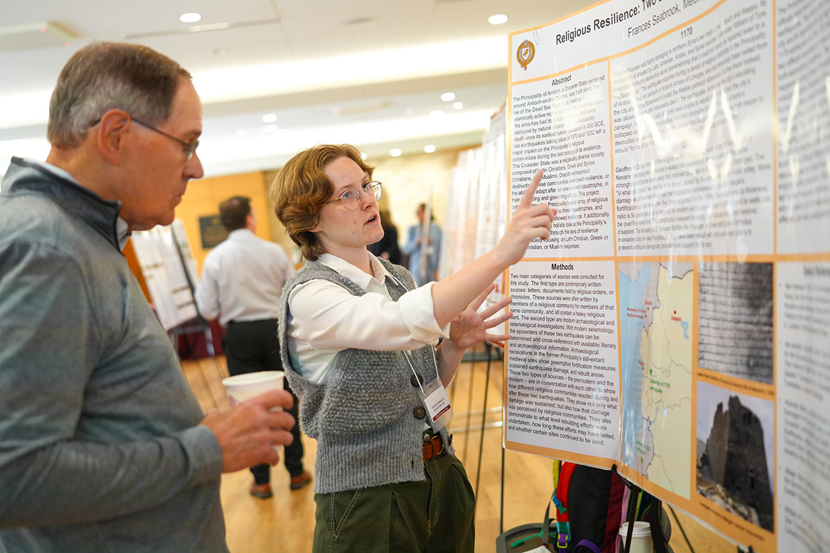 Philosophy student presents her research at a poster session