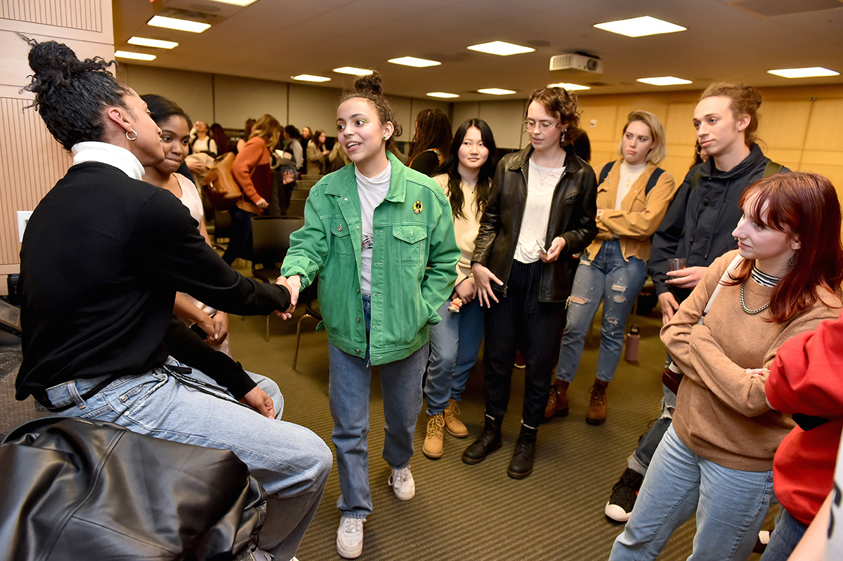 Students approach a lecturer for a post-talk discussion