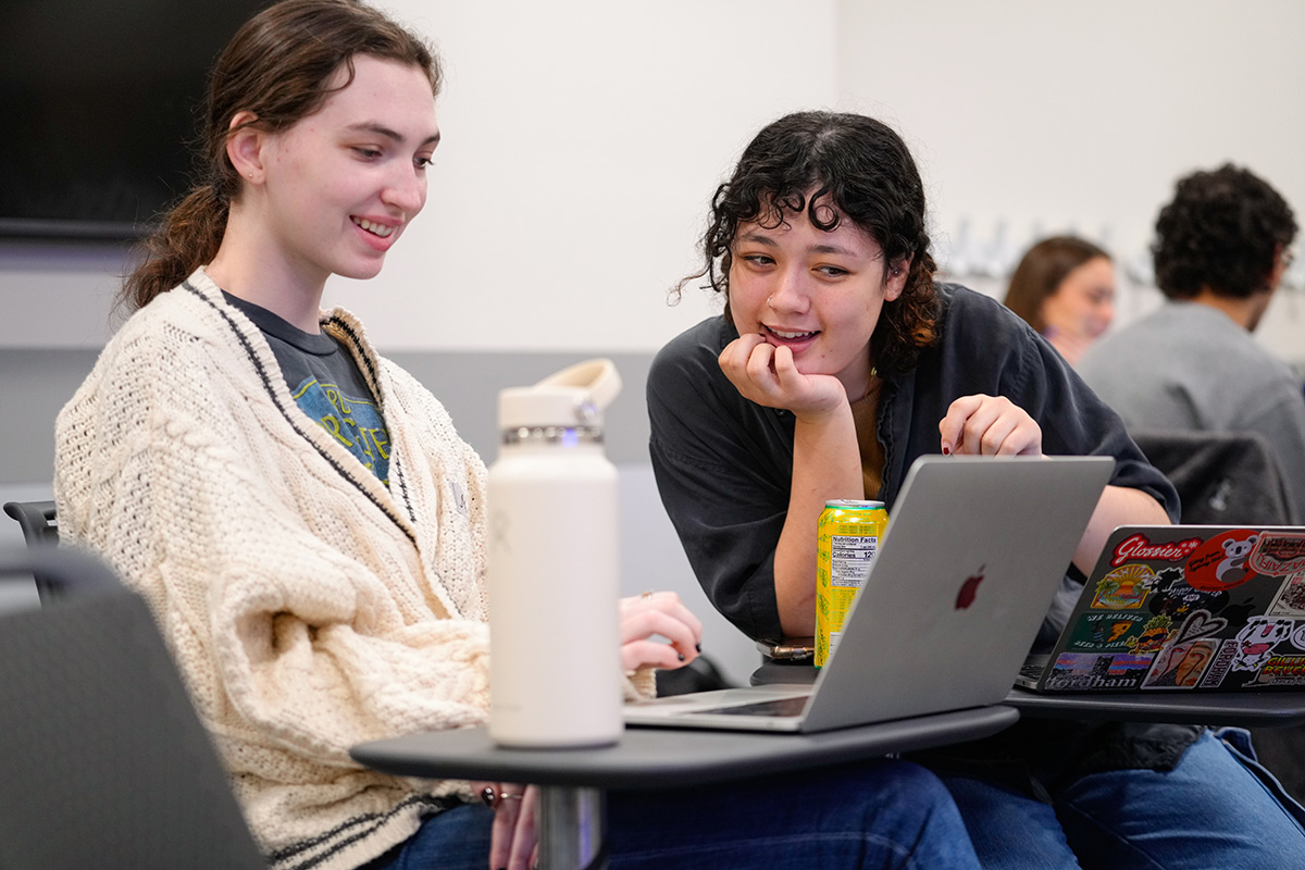 Two female students working on a laptop together