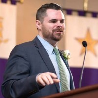 man speaking at podium at an event