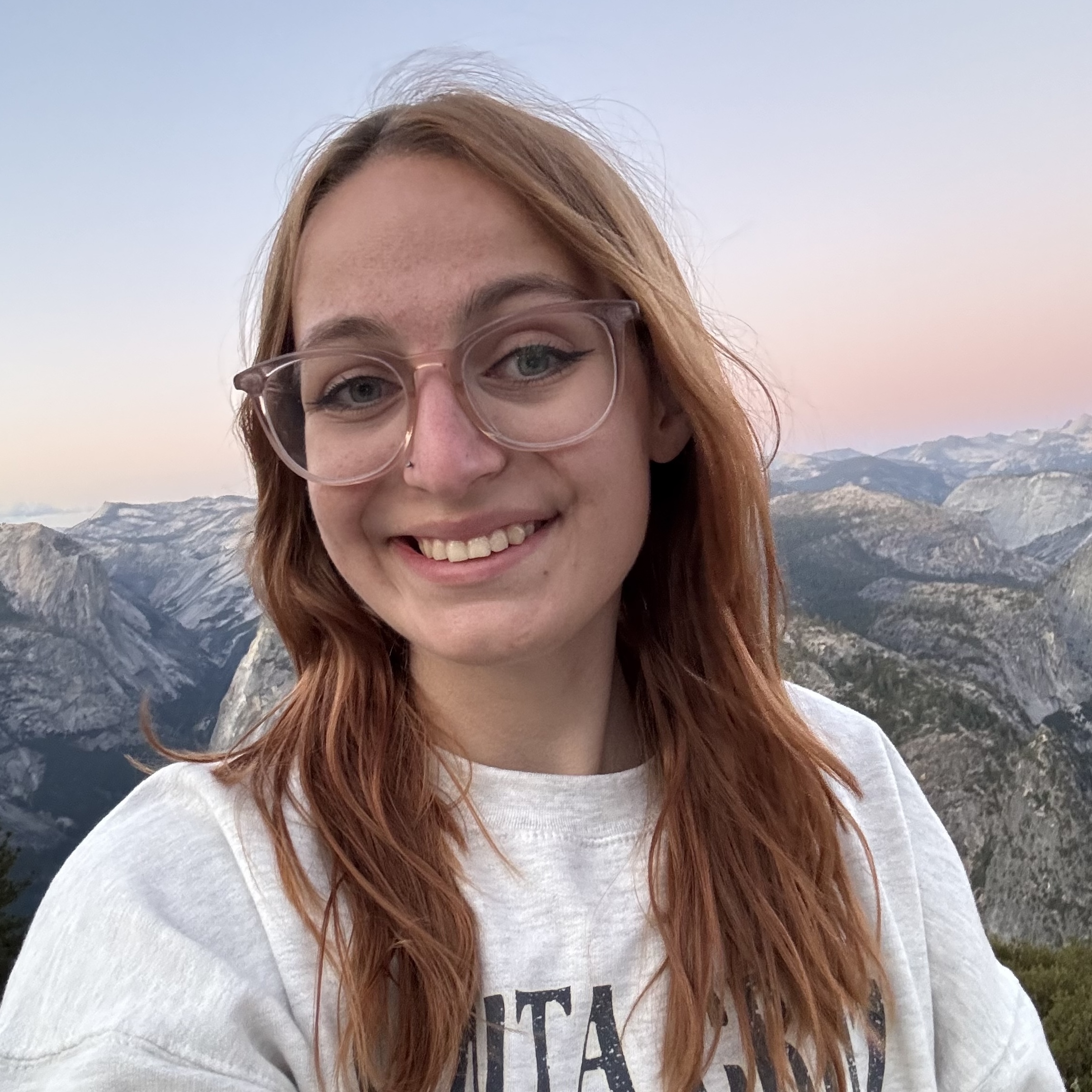 a girl smiling with mountains in the background
