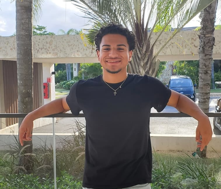 student smiling in front of trees