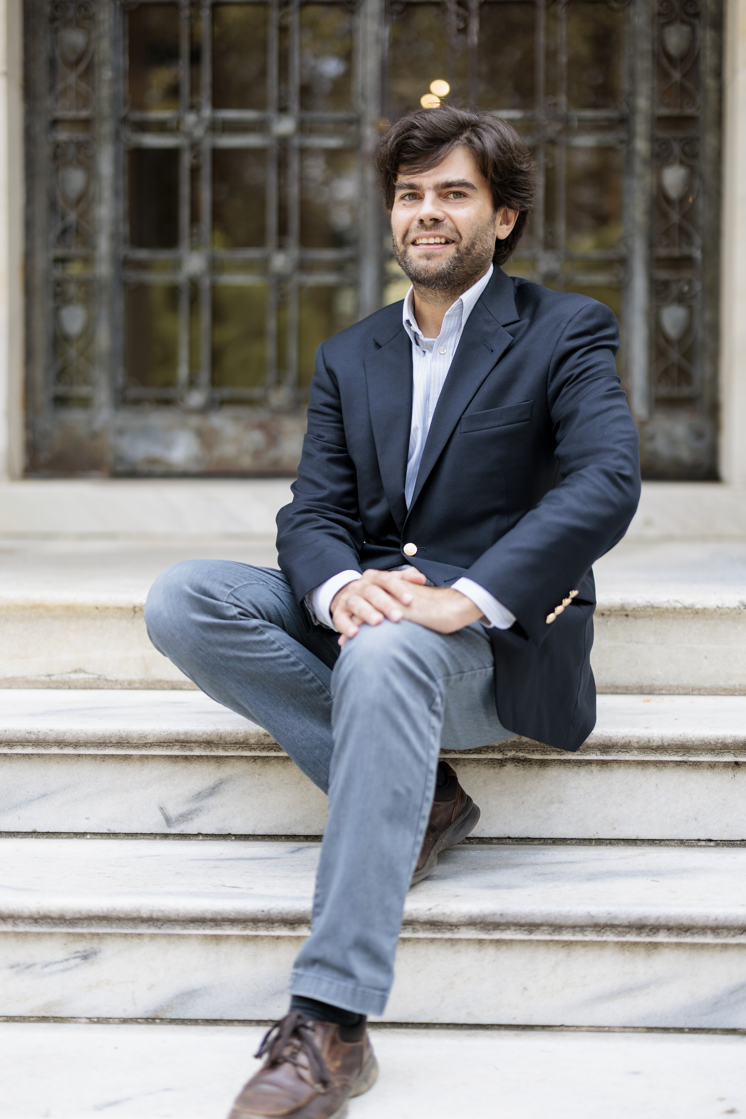 Adam Bermudez sitting in front of Cunniffe House - Rose Hill Campus