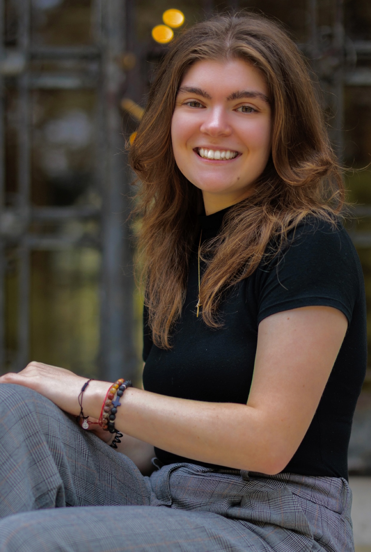 Amanda Caputo sitting in front of Cunniffee House Rose Hill Campus