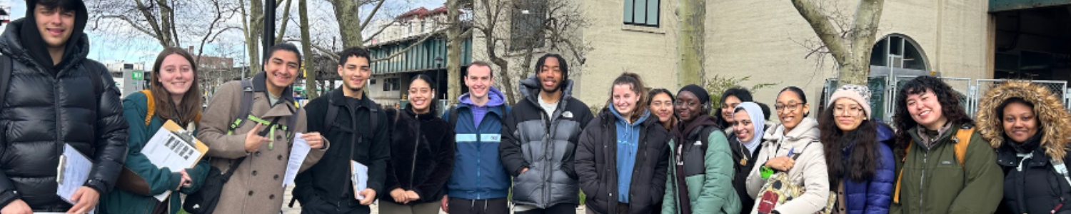 Fordham students with alum Reece Brosco in front of the Parkchester subway station