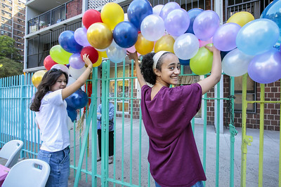 Two Urban Plunge students help to hang an arch of balloons.