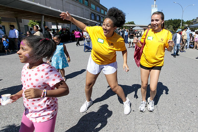 Two Urban Plunge students dance with a young child.